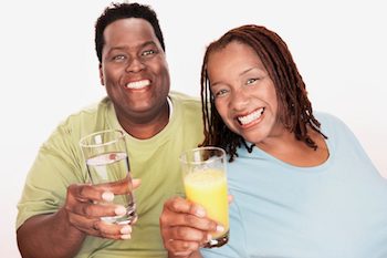 An African American couple holding beverages and smiling about their weight loss